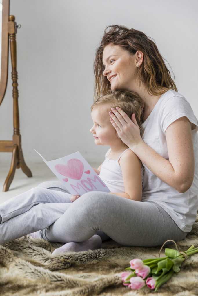 beautiful-smiling-young-woman-with-her-cute-daughter-holding-card-home