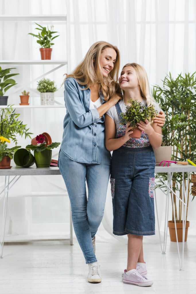 low-angle-smiley-mom-daughter-greenhouse