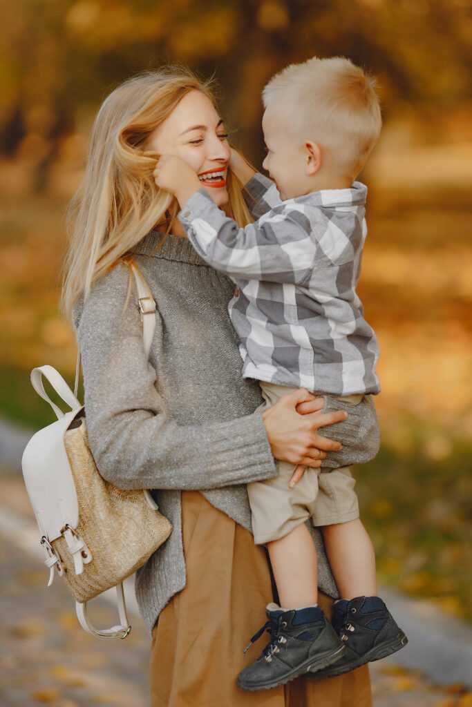 Mother with little son playing in a autumn field
